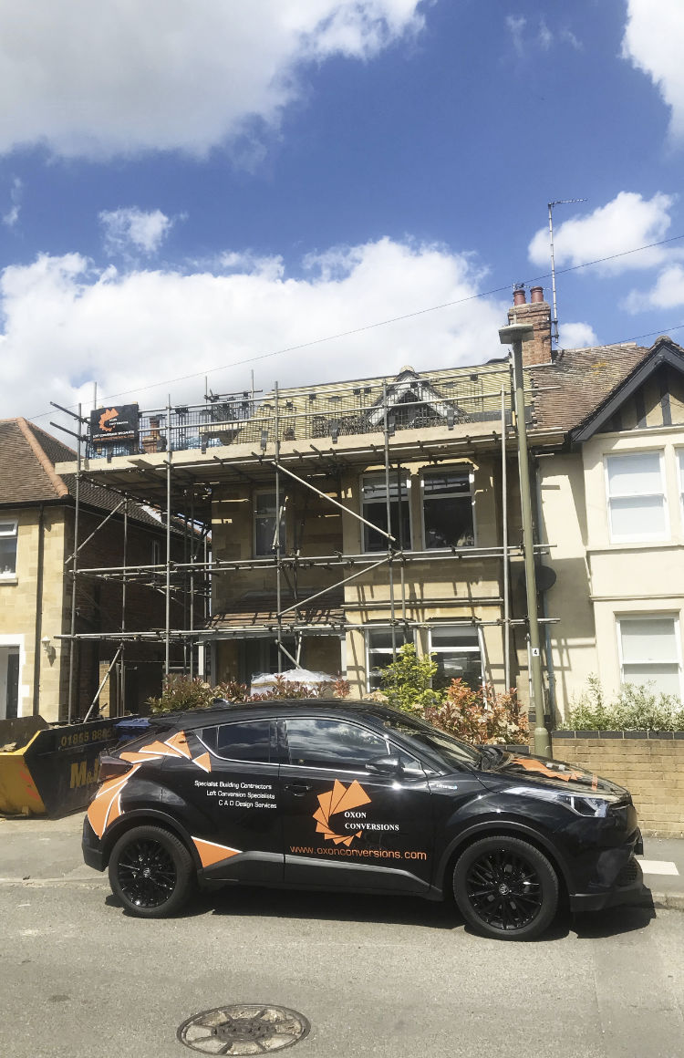 Oxon Conversions car in front of a house being built